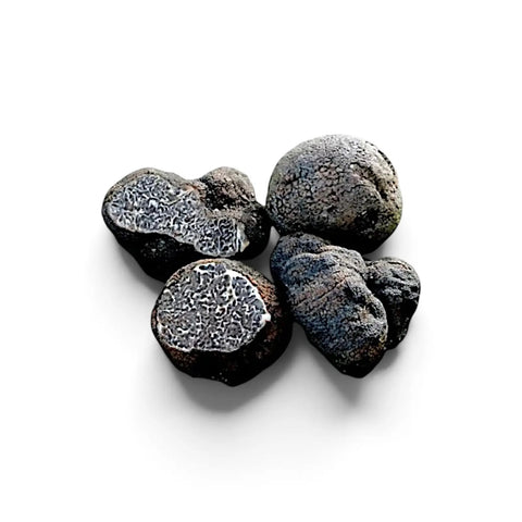Whole and cut Tuber macrosporum smooth black truffles with dark marbled interiors