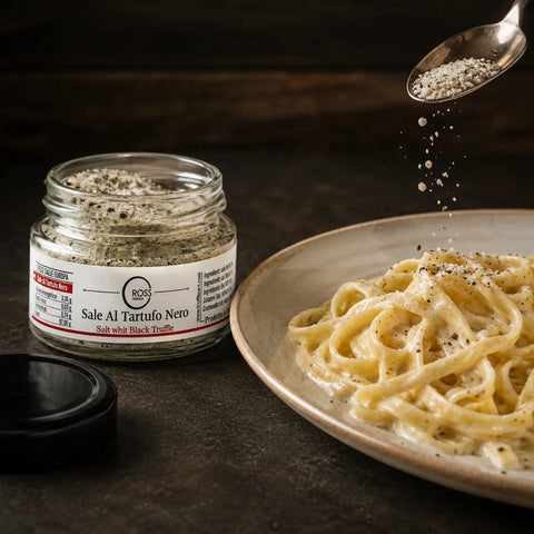 Salz mit schwarzem Trüffel wird vor dem Servieren über warme cremige Tagliatelle gestreut