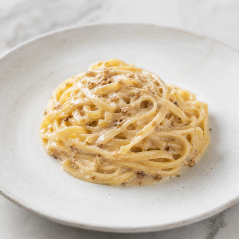 Cremige Pasta mit fein gehacktem gefrorenem Weißen Trüffel (Tuber magnatum)